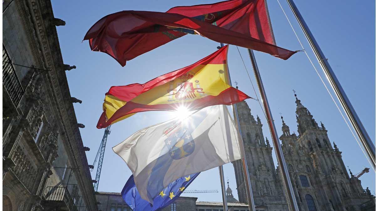 España comienza diez días de luto oficial por las víctimas del coronavirus. En la foto, banderas a media asta en la plaza del Obradoiro, en Santiago de Compostela. En el vídeo, imágenes de edificios oficiales en Madrid.