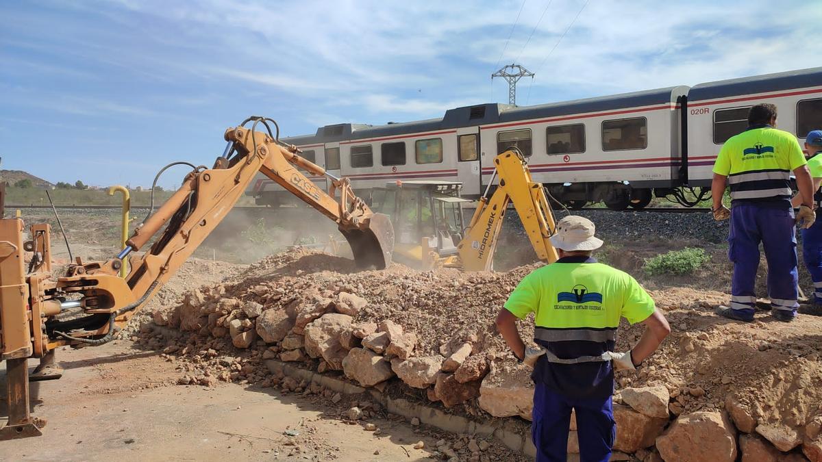 Operarios levantan el muro de contención junto a las vías