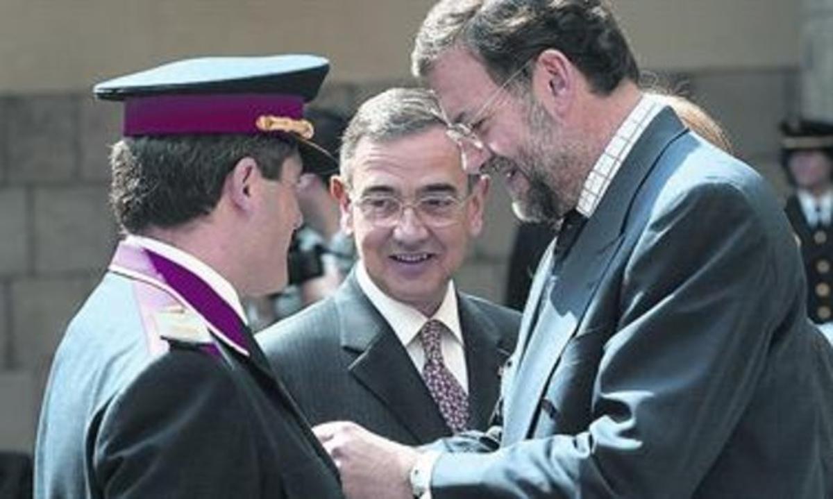 Rajoy, com a ministre de l’Interior el 2002, condecora un agent en presència del conseller Pomés. Rajoy, com a ministre de l’Interior el 2002, condecora un agent en presència del conseller Pomés.