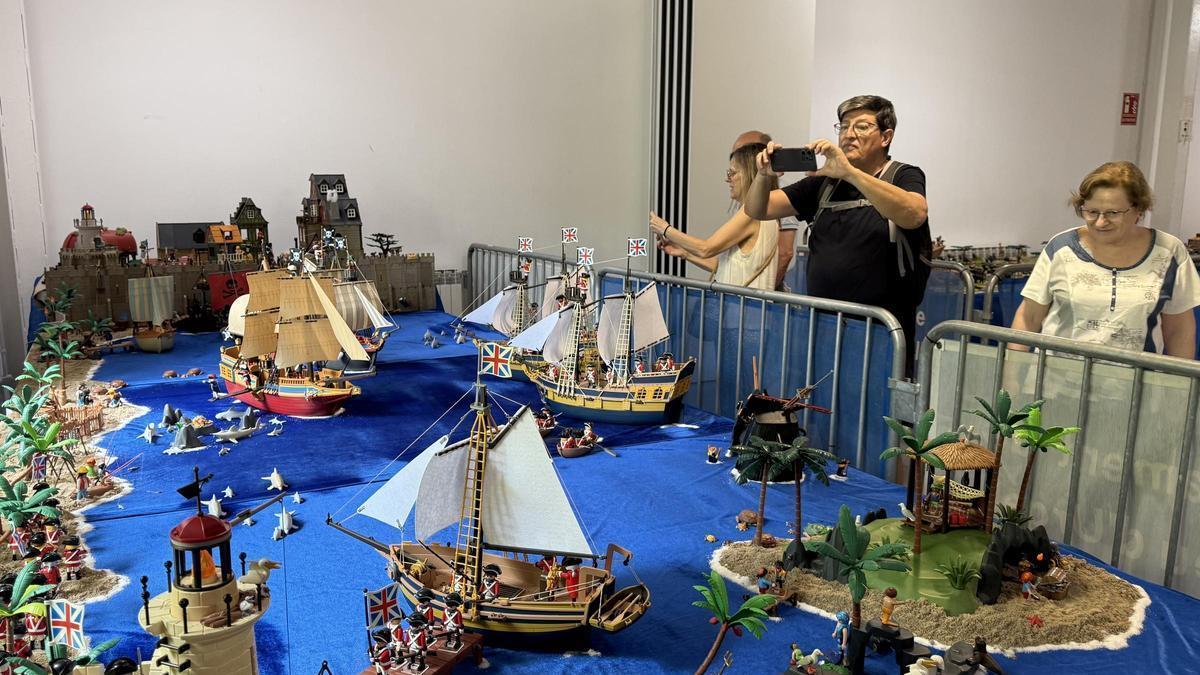 Visitants fent fotografies d'un dels diorames exposats