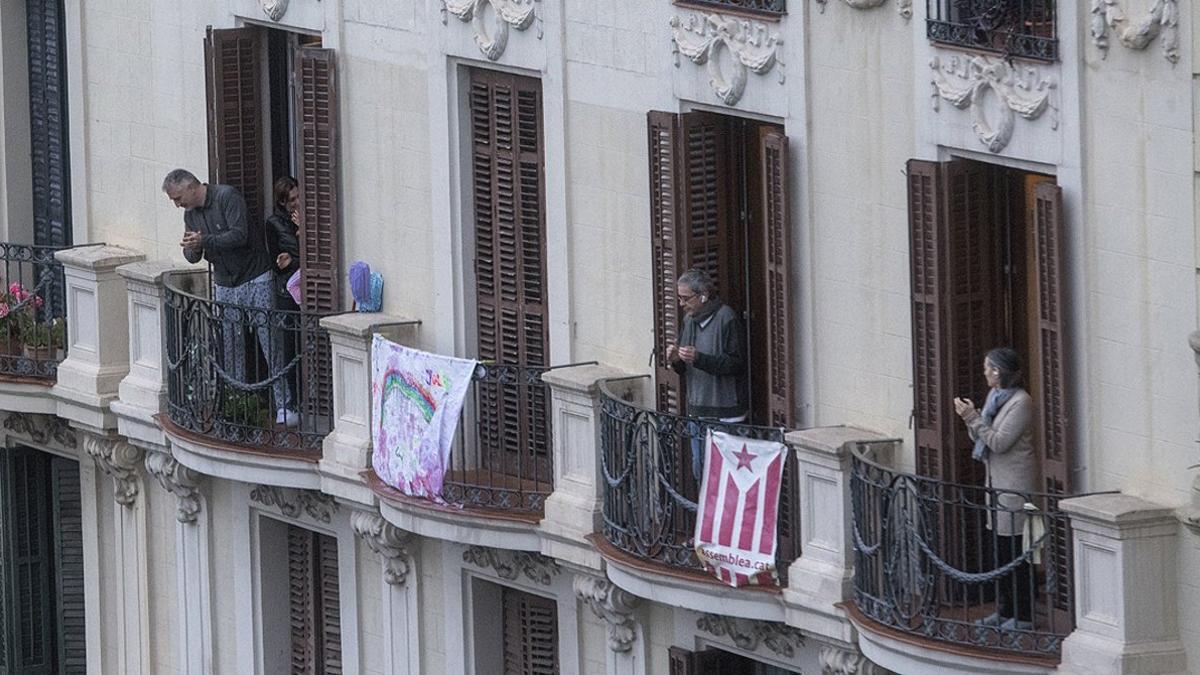 Varios vecinos del Eixample de Barcelona aplauden a los sanitarios desde sus balcones, el pasado 30 de marzo