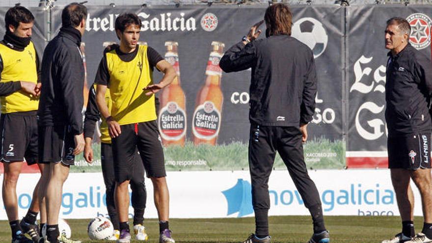 Borja Oubiña conversa con el preparador físico del Celta, Fran Albert, en presencia de Andrés Túñez, el segundo técnico céltico, Ángel Rodríguez, de espaldas, y Paco Herrera en el campo de A Madroa. //  Marta G. Brea