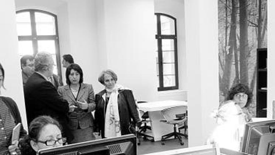 Antonio Trevín, Begoña Fernández y Paz Fernández Felgueroso, al fondo, observan a los usuarios de «Gijón orienta».