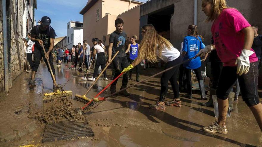 Voluntarios en pleno trabajo de limpieza tras la riada en el pueblo de Sant LlorenÃ§.