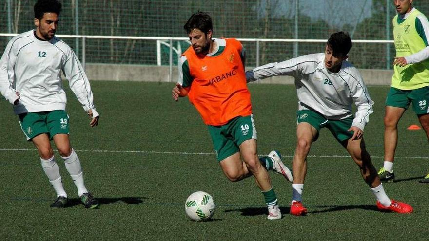 Pibe, del Coruxo, intenta frenar a Pedro Vázquez en el entrenamiento de ayer en Fragoselo. // R.R.