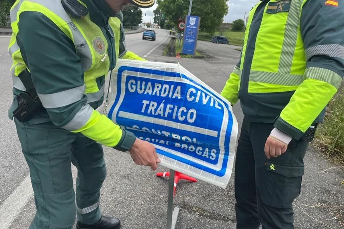 Guardias civiles inician un control de drogas en una carretera.
