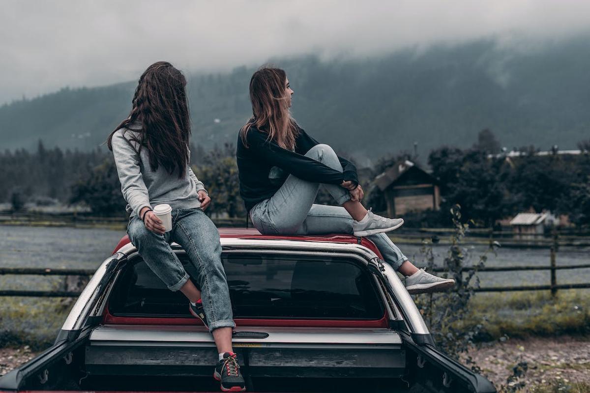 Dos adolescentes sentadas en el techo de un coche