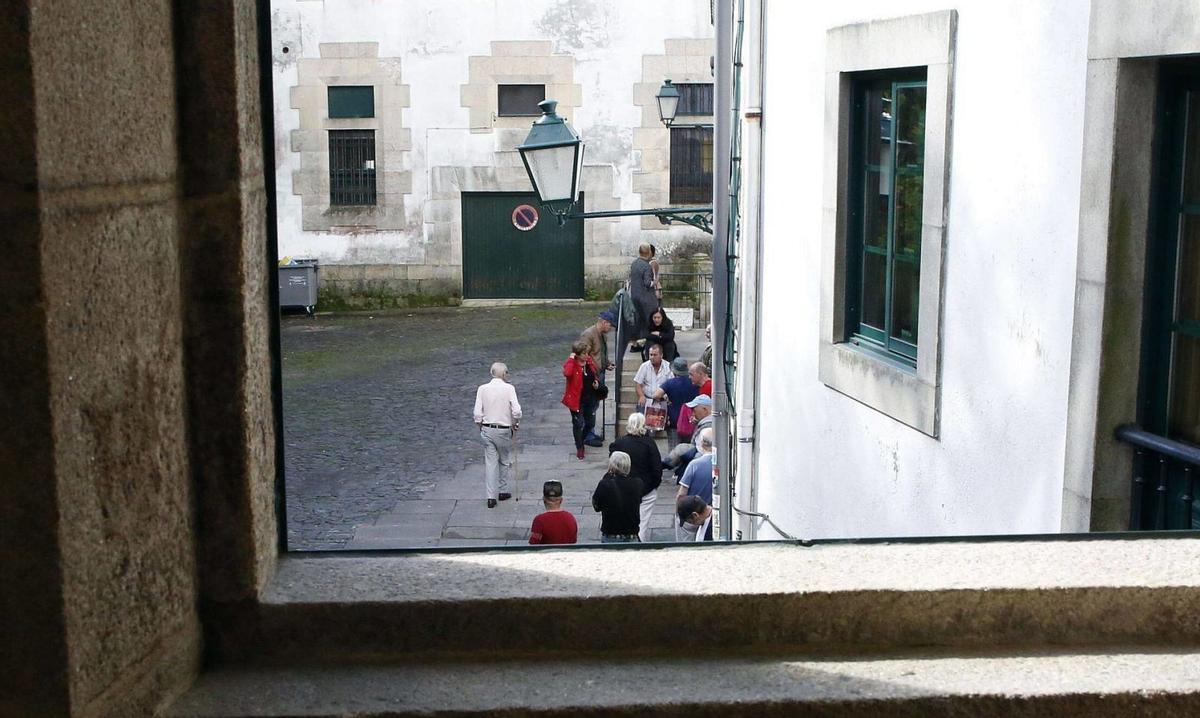 Un grupo de personas hace cola para acceder a la Cocina Económica