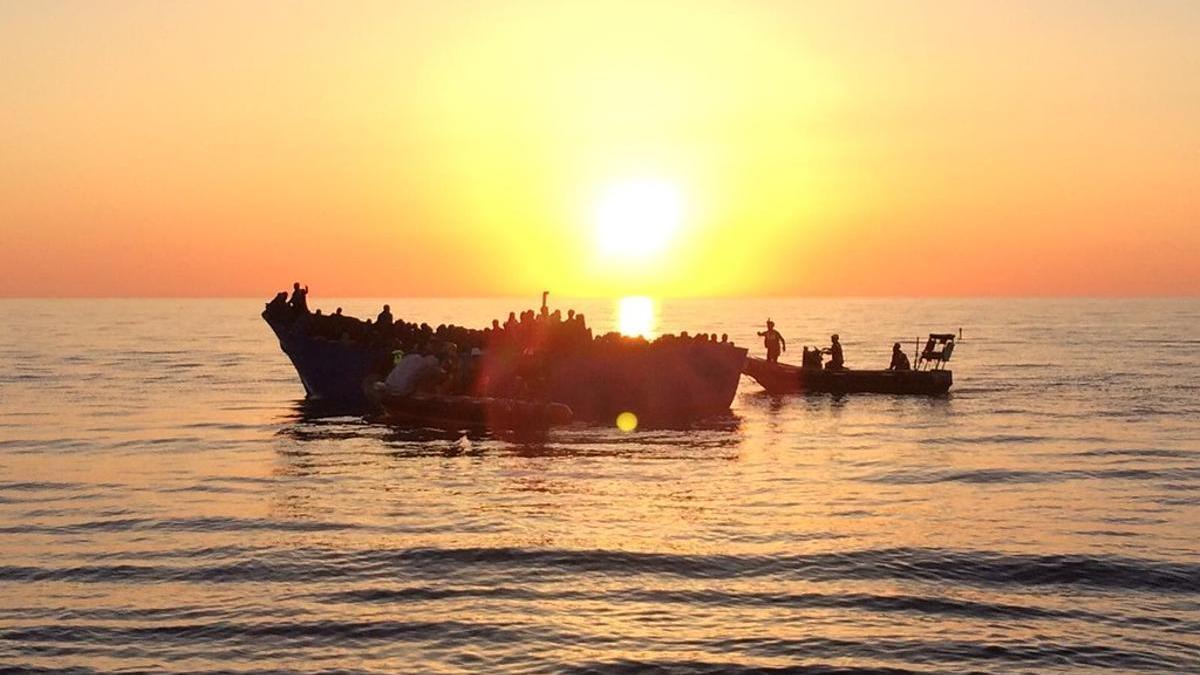 Centenares de personas intentan cruzar el Mediterráneo en una pequeña embarcación.