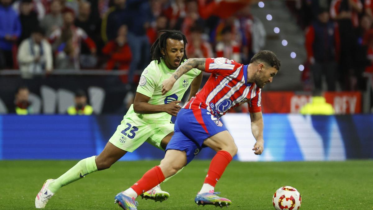 MADRID, 02/04/2025.- El defensa del Atlético de Madrid, Javi Galán (d), se lleva el balón ante el defensa francés del FC Barcelona, Jules Koundé, durante el encuentro correspondiente a la vuelta de las semifinales de la Copa del Rey que disputan hoy miércoles Atlético de Madrid y FC Barcelona en el estadio Metropolitano, en Madrid. EFE / JUANJO MARTIN