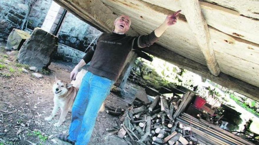 Juan Antonio, vecino de Casares, muestra el deterioro que la salazón ha causado en la madera del piso del hórreo.