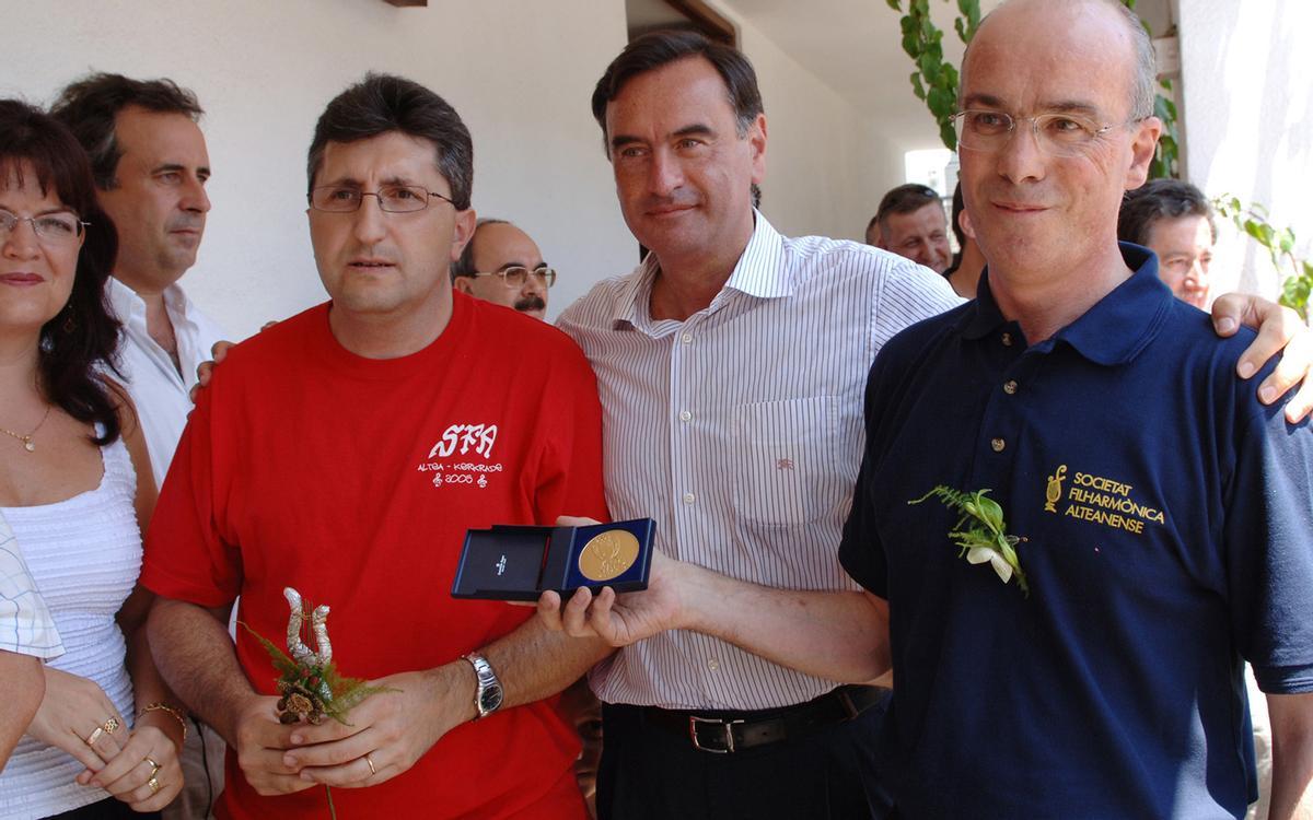 Luís Morote, presidente de la SFA, muestra la medalla de oro conseguida por la banda en el certamen de Kerkrade de 2005. A su lado, el alcalde de Altea, Miguel Ortiz, y el director de la banda, Daniel Ferrero.