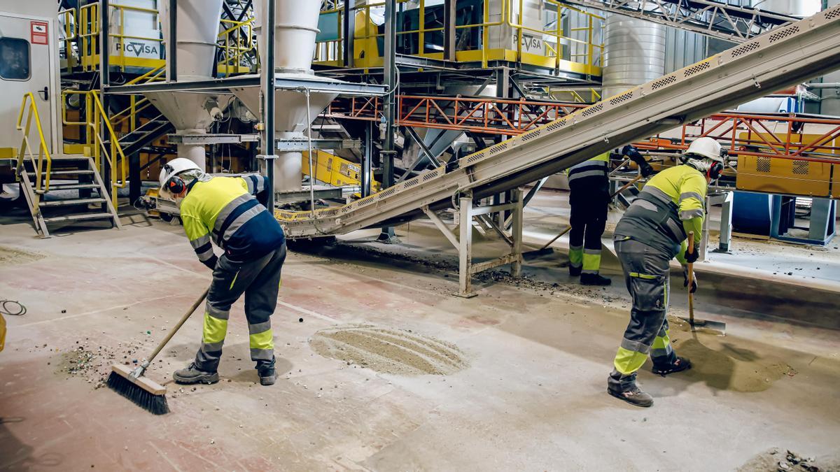 Dos trabajadores en un fábrica de vidrio.