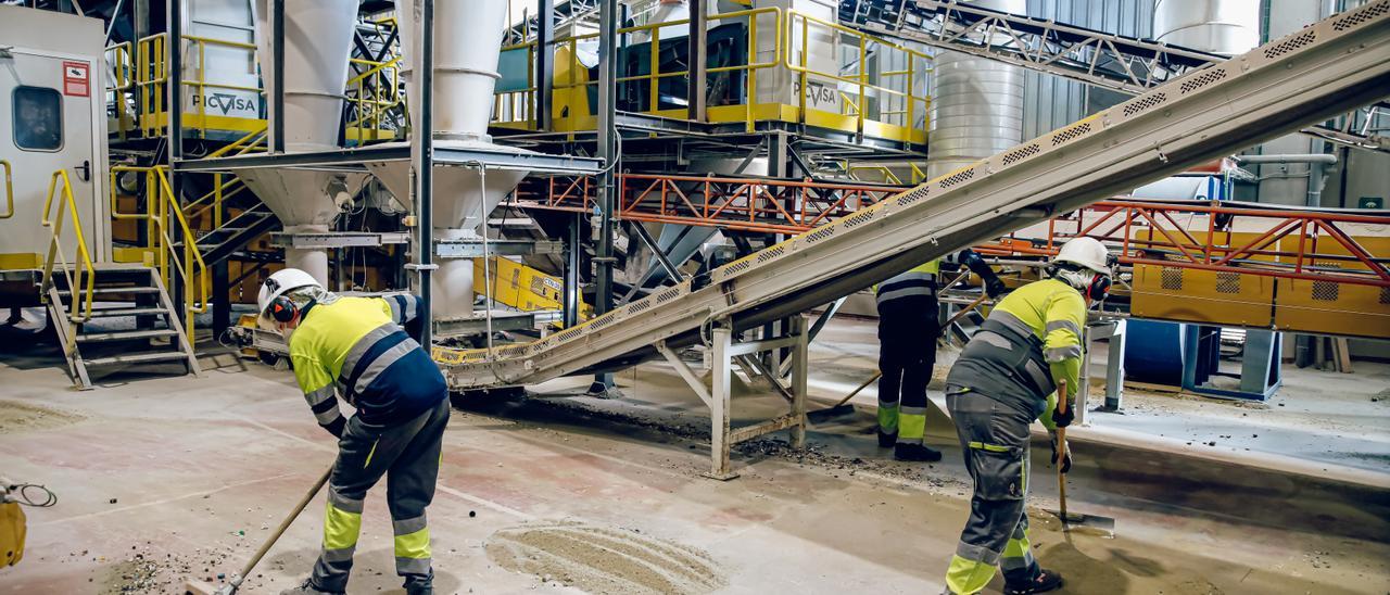 Dos trabajadores en un fábrica de vidrio.