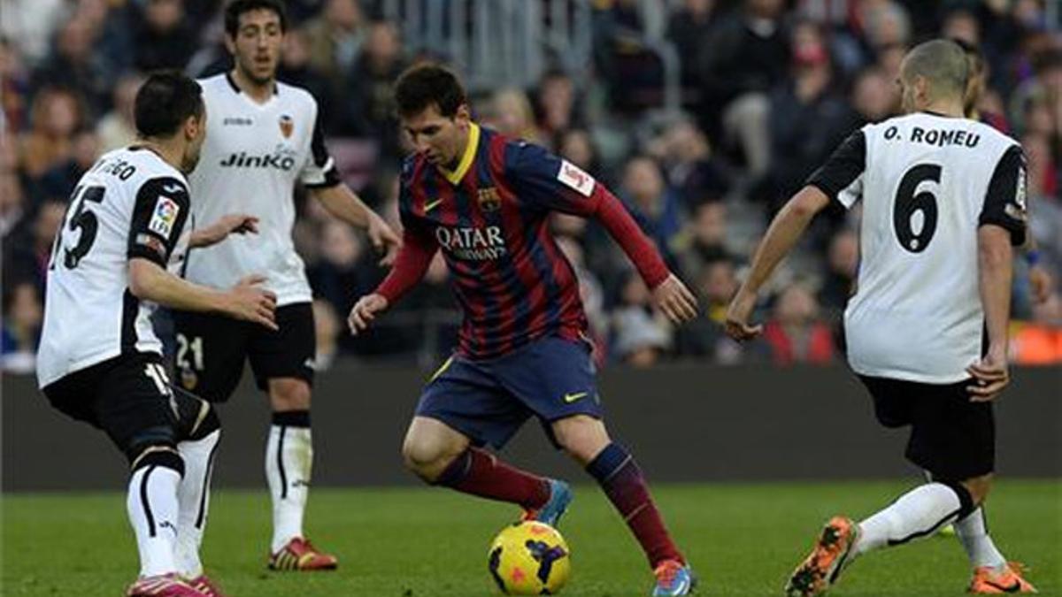 Messi, entre rivales del Valencia en el partido de la temporada pasada