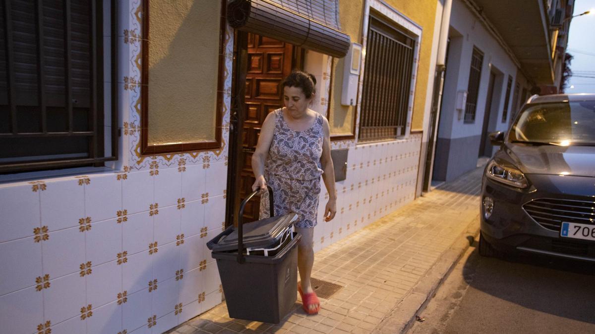 Una vecina de Alcàntera deja el cubo de basura a la puerta de casa en una imagen de archivo.