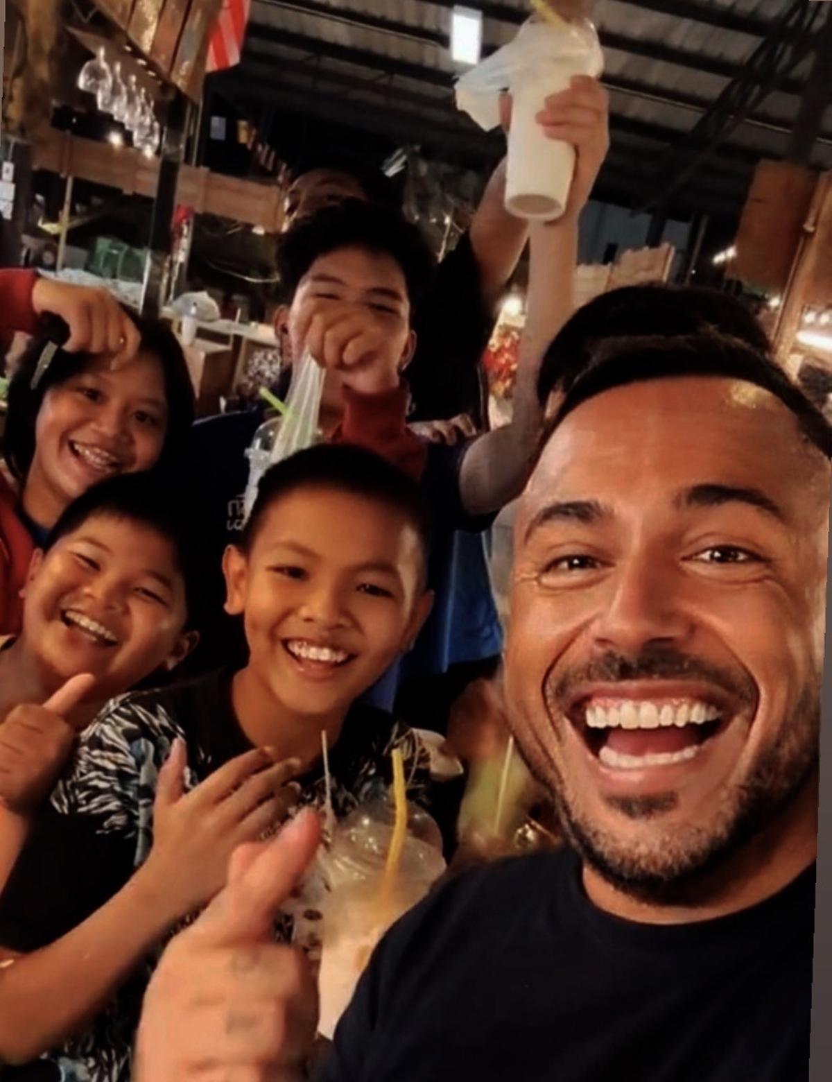 Jesús Marteles junto a varios niños en un mercado de Tailandia