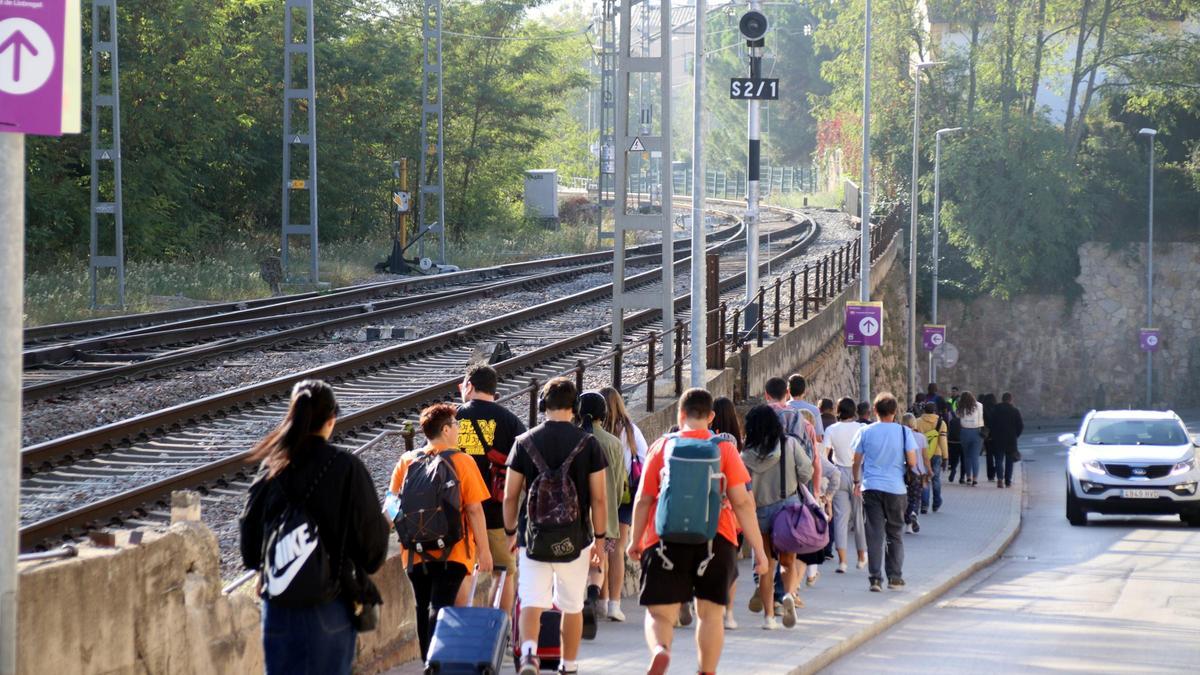 Viajeros del tren, en Centelles, se dirigen a la parada de bus para seguir su camino, durante el corte de la R3, en octubre de 2023