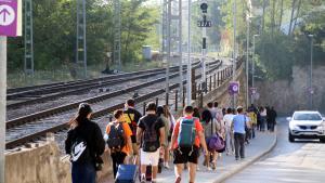 Viajeros del tren, en Centelles, se dirigen a la parada de bus para seguir su camino, durante el corte de la R3, en octubre de 2023