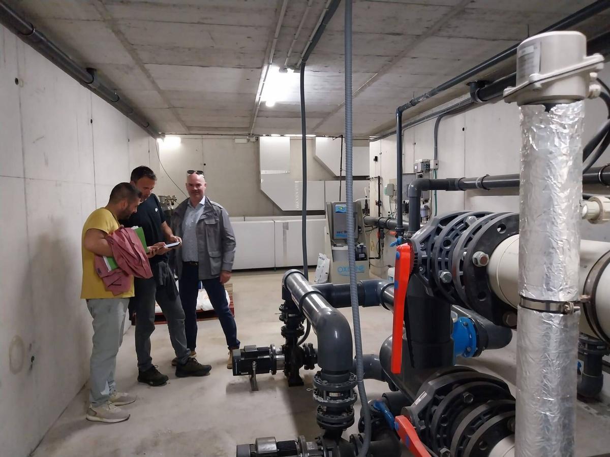 Xosé Leal y Félix Juncal junto al responsable de Viraxes en las entrañas de la piscina municipal.