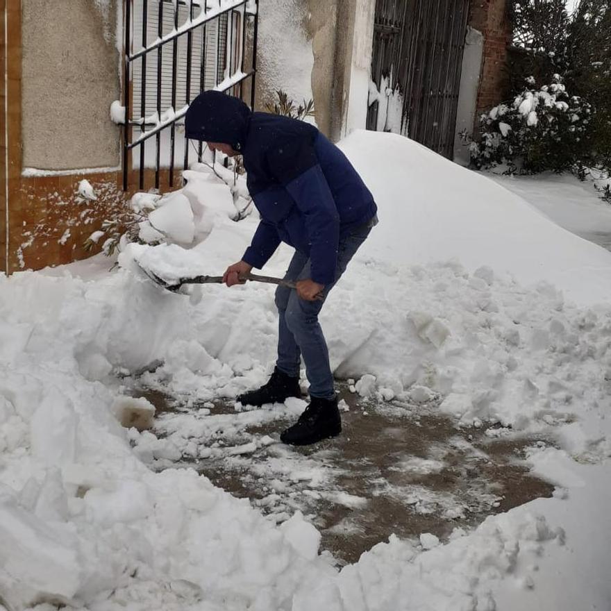 Un vecino de El Pego retira con una pala la nieve acumulada junto a una vivienda