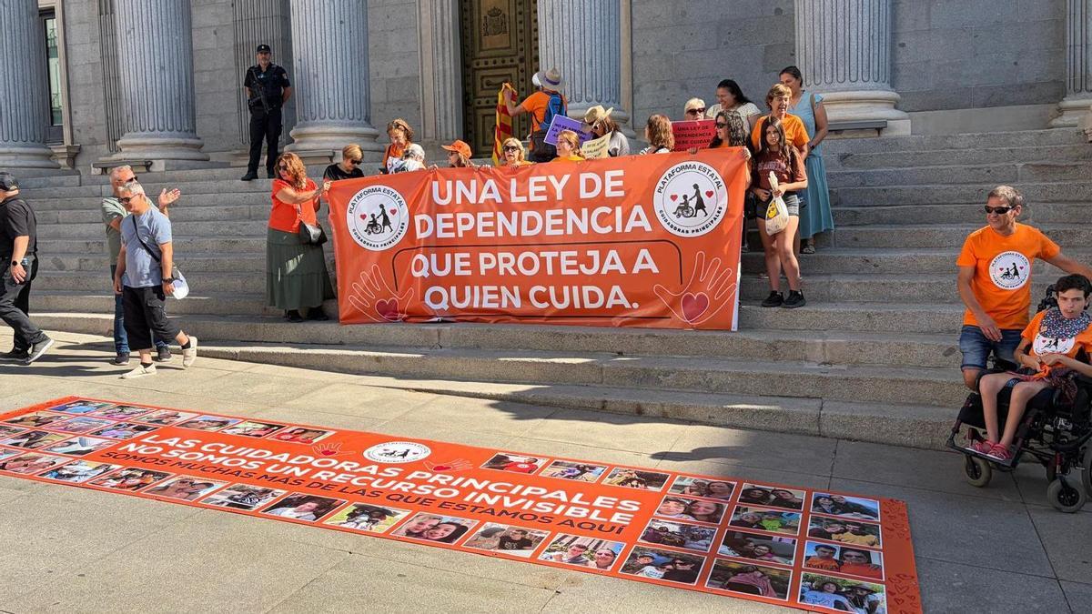 Las protestas de cuidadoras ante el Congreso tuvieron hoy rostro gallego: Belén Feijóo y su hijo Olegario