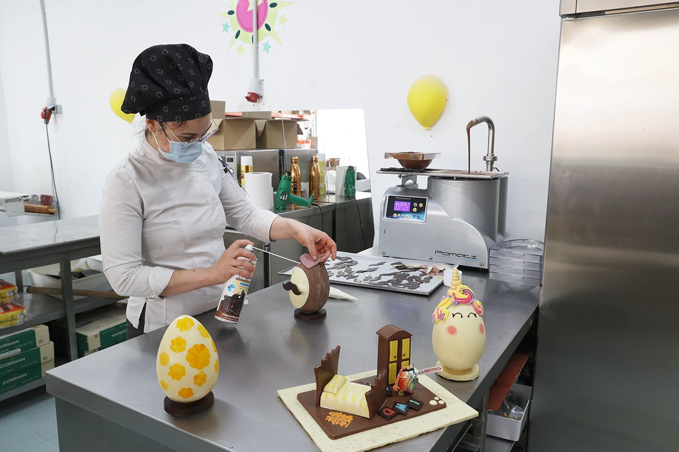 Una confitera, trabajando el chocolate para los  huevos de Pascua en El Trigal.