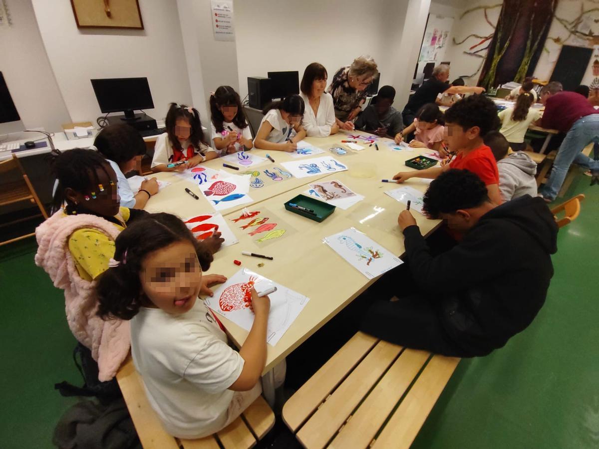 Alguns infants treballant en l'elaboració del mural.