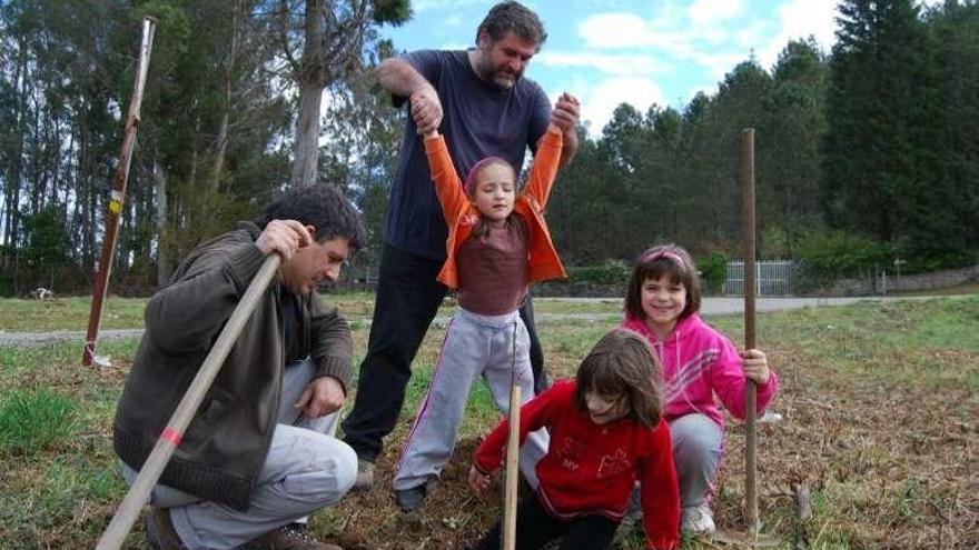 Unos niños plantan árboles en el monte de A Picaraña. // D.P.