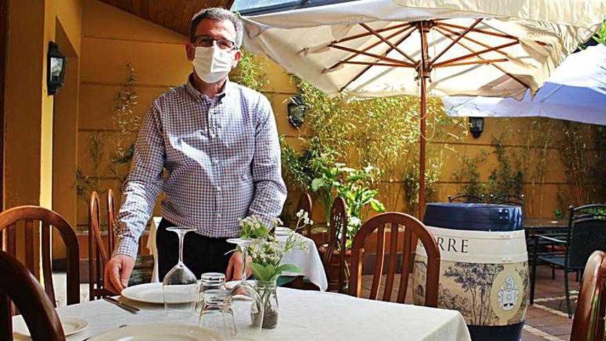 José Manuel Pérez, gerente de La Villa Blanca (Luarca), prepara una de las mesas de su terraza cubierta. | T. Cascudo