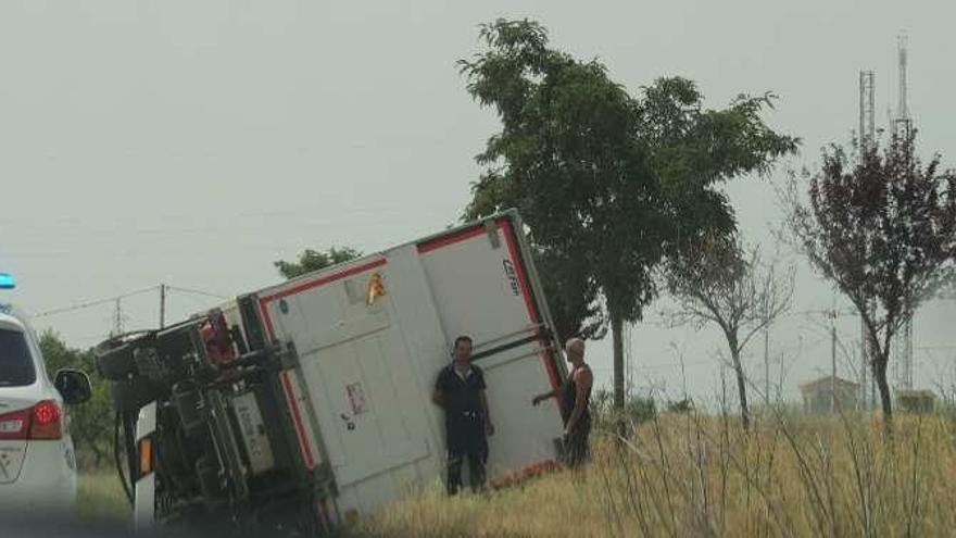 El camión volcado junto a la vía.