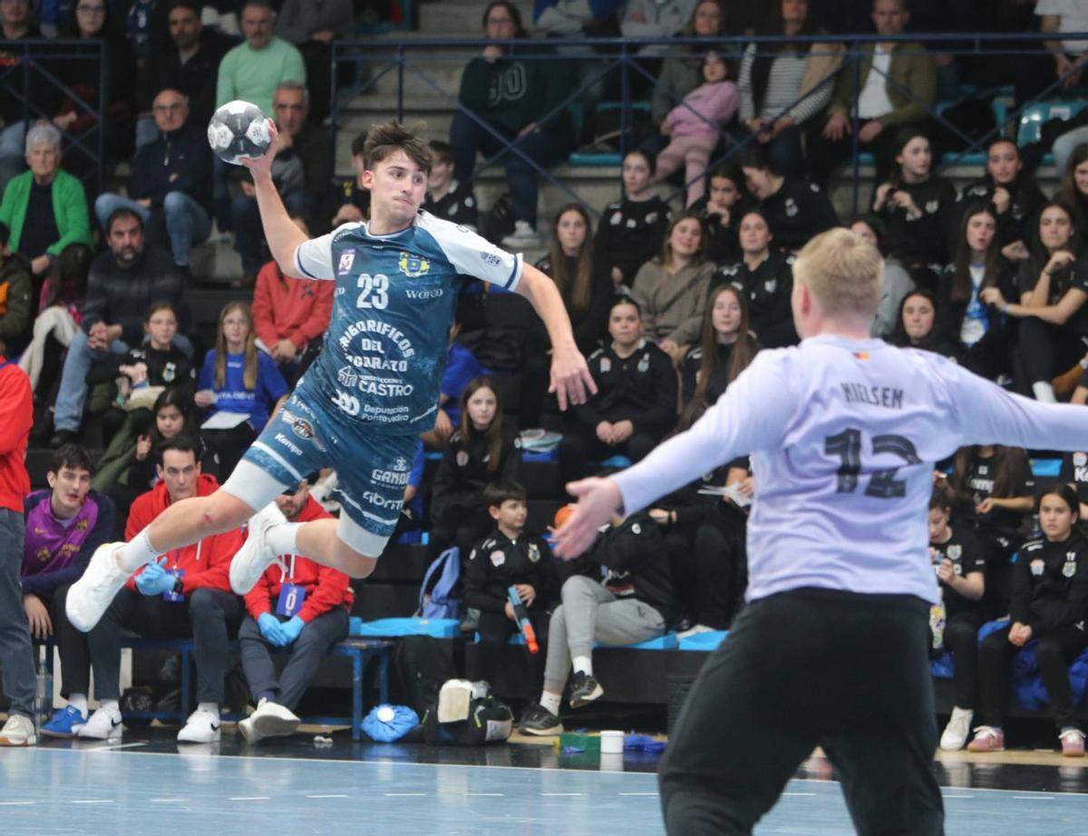 Martín Fuentes, en el aire para efectuar un lanzamiento ante Emil Nielsen. | SANTOS ÁLVAREZ