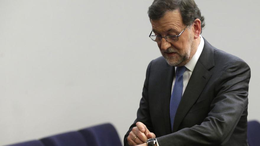 Mariano Rajoy consulta su reloj tras finalizar la rueda de prensa.