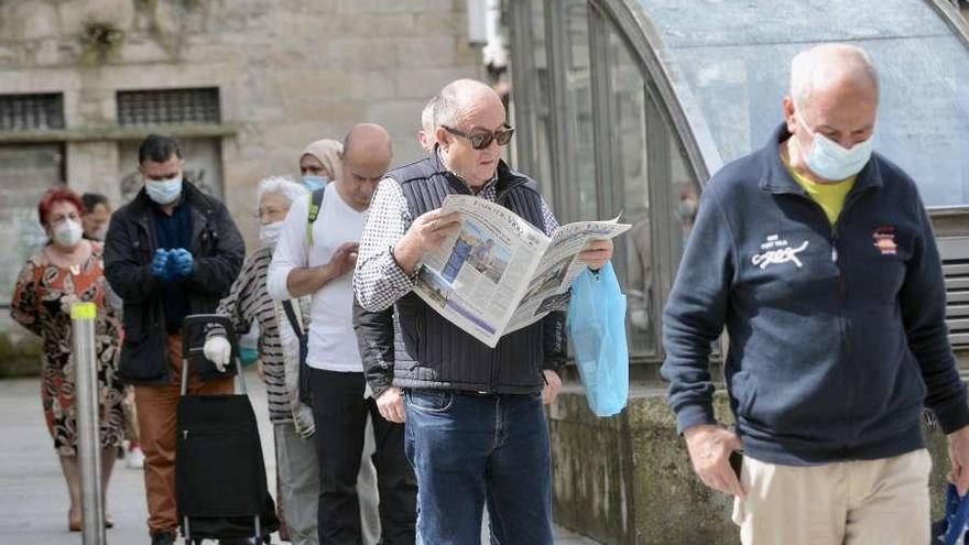 Cola de gente esperando para acceder a la plaza de abastos de Pontevedra. // Rafa Vázquez