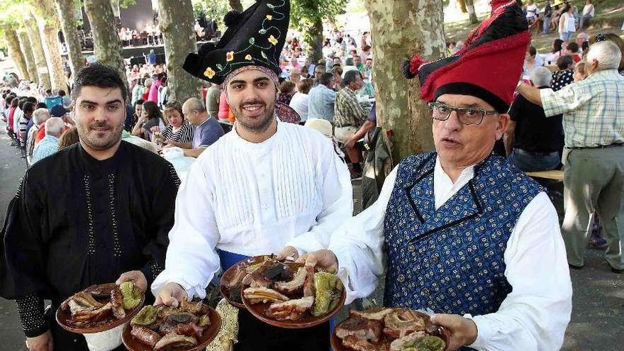 Tres asistentes a la fiesta del Churrasco de Covelo, con sus raciones. // Hernández M. A.