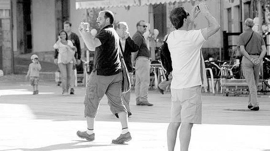 Dos turistas sacan fotografías en El Parche.