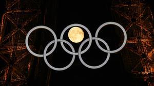 La luna llena, a través de los aros olímpicos en la Torre Eiffel.