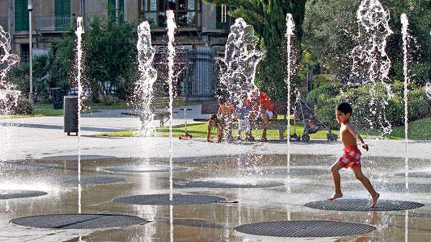 Un niño juega en la fuente mientras el agua sube y baja al ritmo de la música clásica.