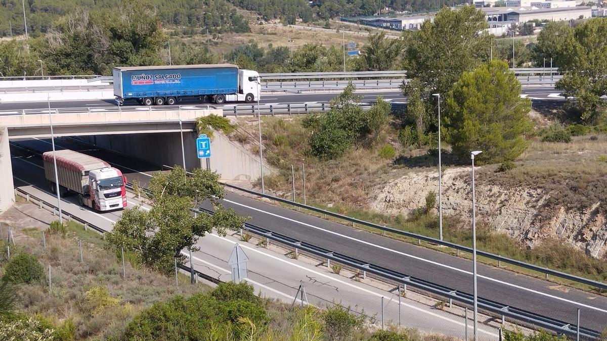 A la part superior, un camió circulant per l'autopista a l'entrada del peatge troncal, i a sota un entrant-hi pel vial lateral