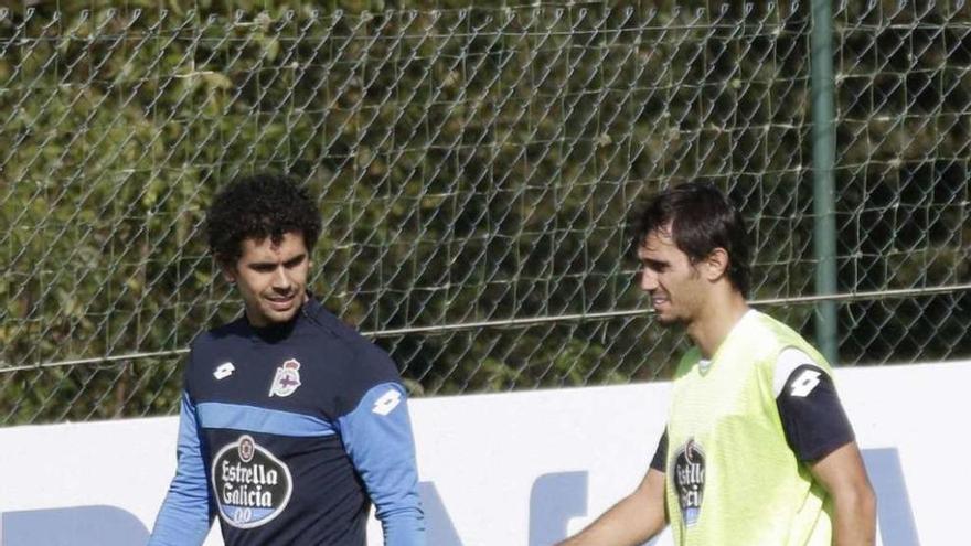 Alejandro Arribas se retira del entrenamiento en compañía de uno de los fisioterapeutas del equipo.