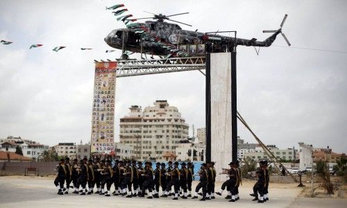 The broken helicopter of late Palestinian President Yasser Arafat is placed on top of a structure as members of Palestinian security forces loyal to Hamas march during a military graduation ceremony in Gaza City