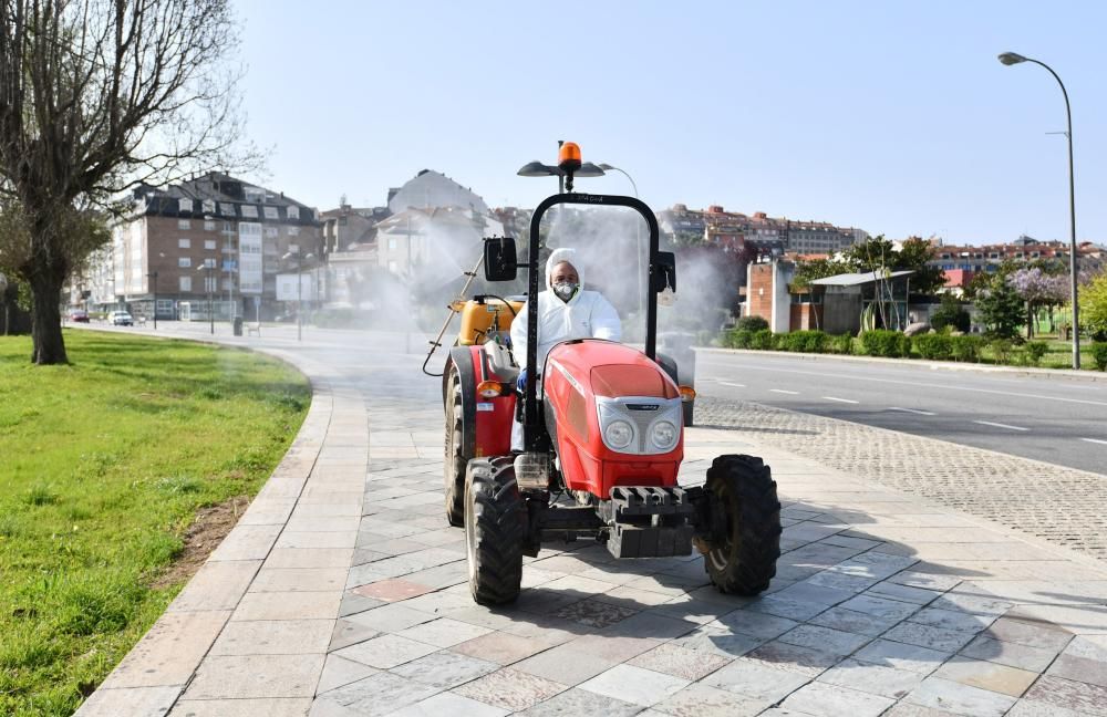 Subidos en un tractor y cargados de desinfectante en sus fumigadoras trabajan desde ayer los vecinos de Sanxenxo en la limpieza del municipio. // Gustavo Santos