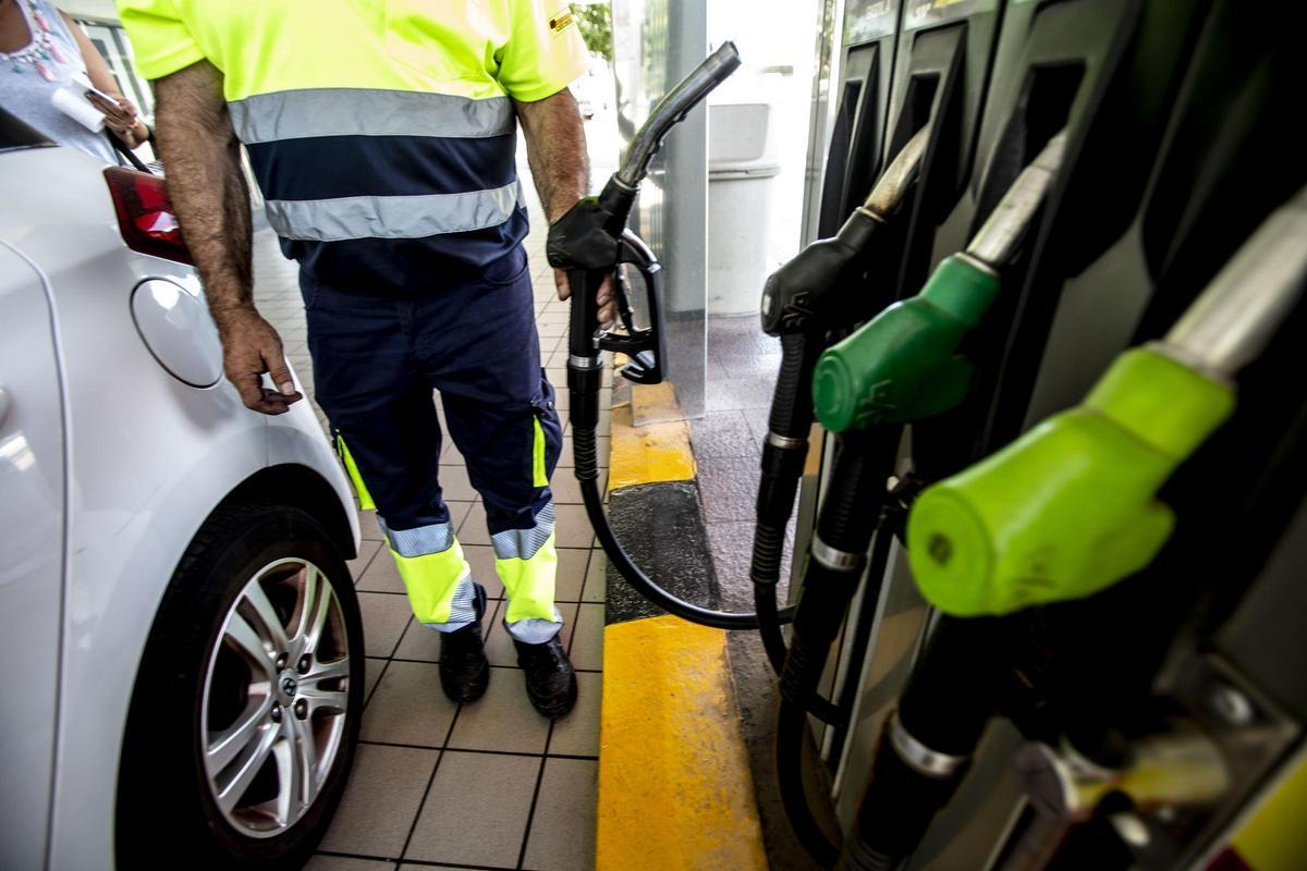 El empleado de una estación de servicio de Alicante se dispone servir combustible.