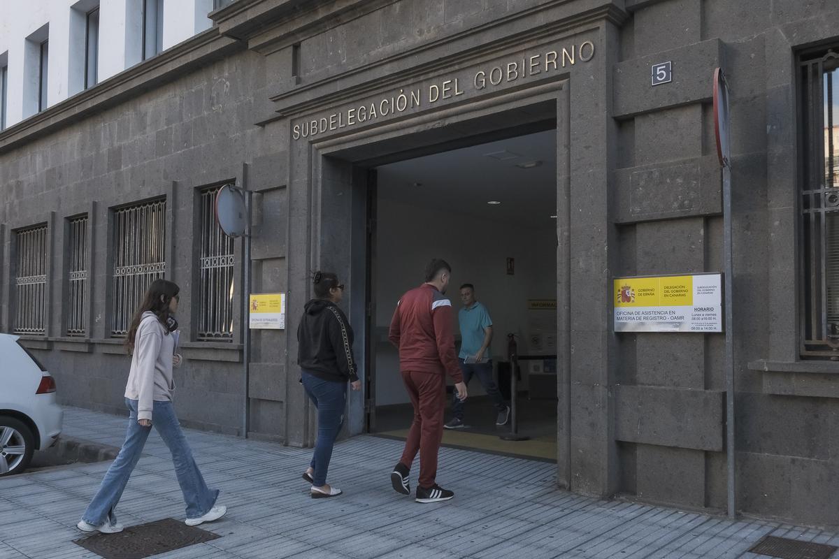 Tres personas entran al área de Extranjería, en Las Palmas de Gran Canaria.