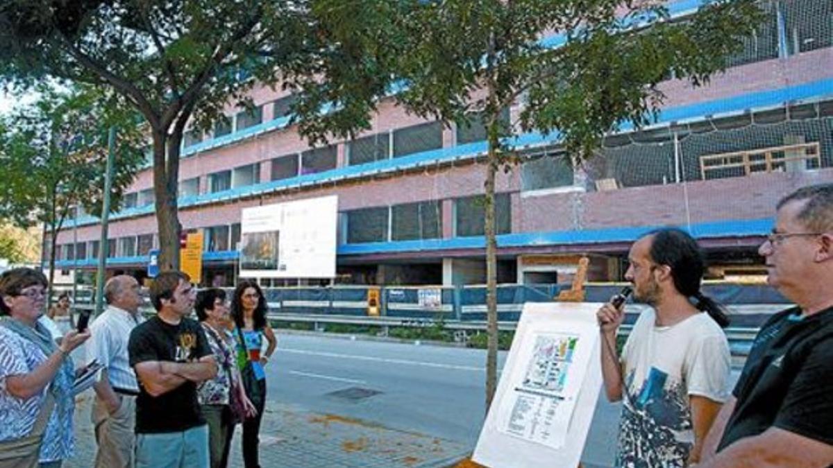 El presidente de la asociación de vecinos, con el micrófono, frente a las obras del futuro centro sociosanitario.