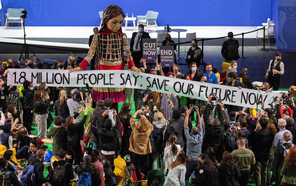 delegados y participantes se reúnen alrededor de Little Amal, durante la Cumbre del Clima COP26 de la ONU en Glasgow