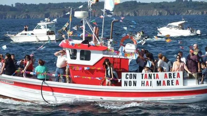 Barcos con pancartas de protesta en la procesión de las fiestas de Lorbé.