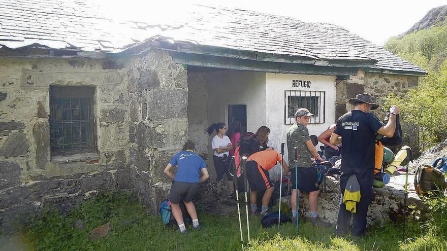 Un grupo de excursionistas a la entrada del refugio de la Presa Rota.