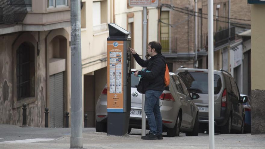 Un home paga la zona blava, a Manresa.