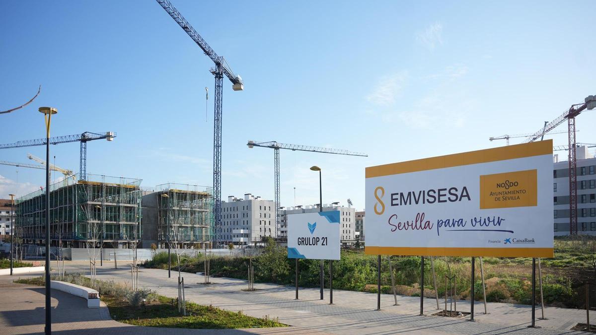 Un cartel de EMVISESA, frente a una obra de VPO en Sevilla.